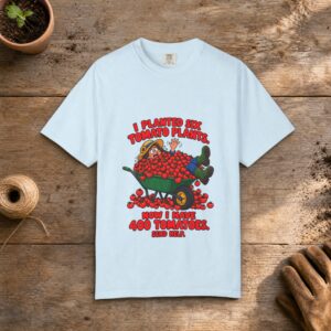 400 Tomatoes gardening t-shirt in Chambray, laid flat on a potting bench with gardening gloves and a trowel