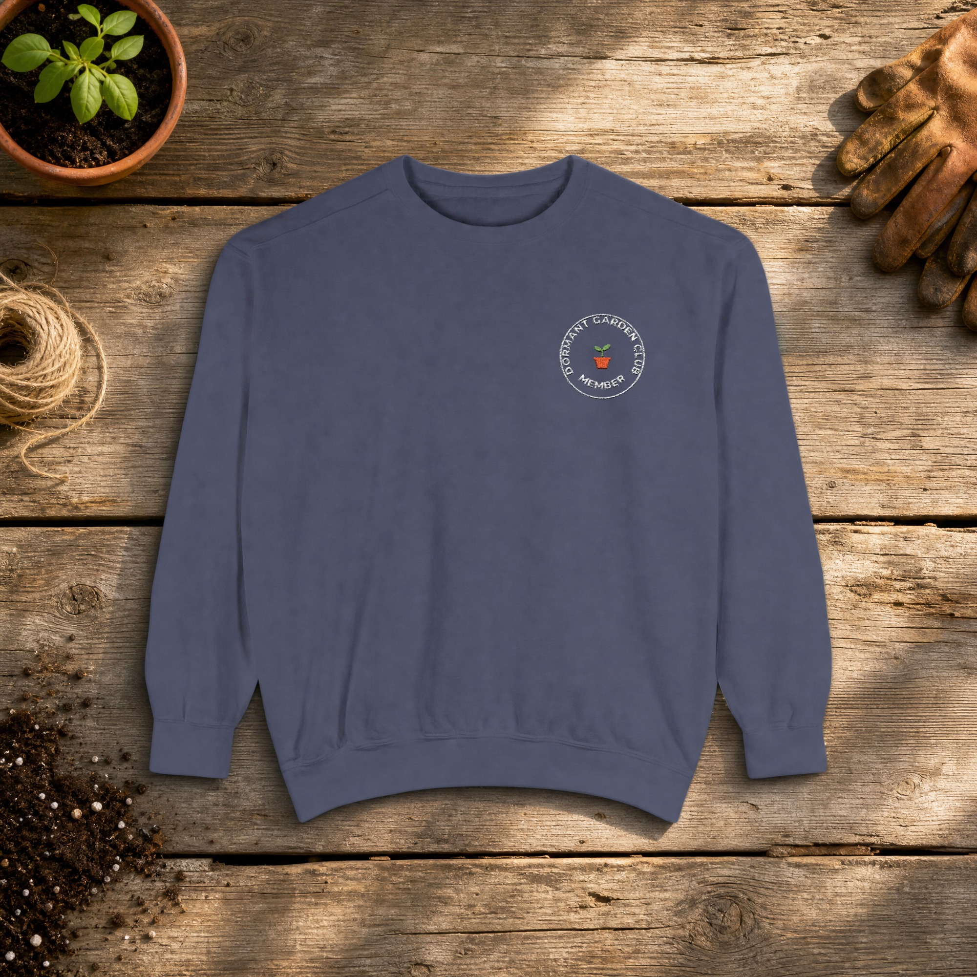 Dormant Garden Club Member Embroidered Sweatshirt in Denim, an embroidered crewneck sweatshirt on a potting bench