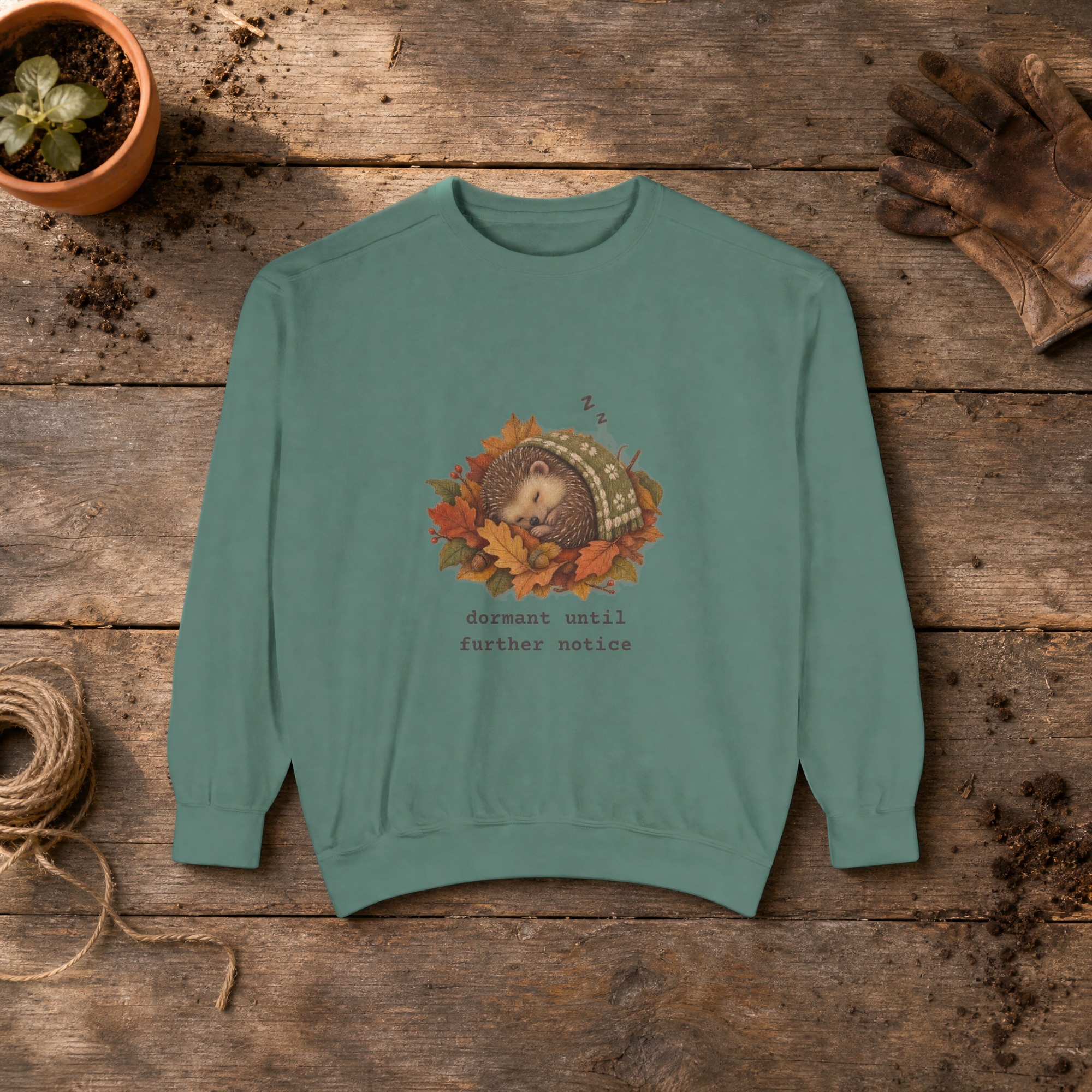 Dormant Until Further Notice Sweatshirt in Light Green, a crewneck sweatshirt on a potting bench