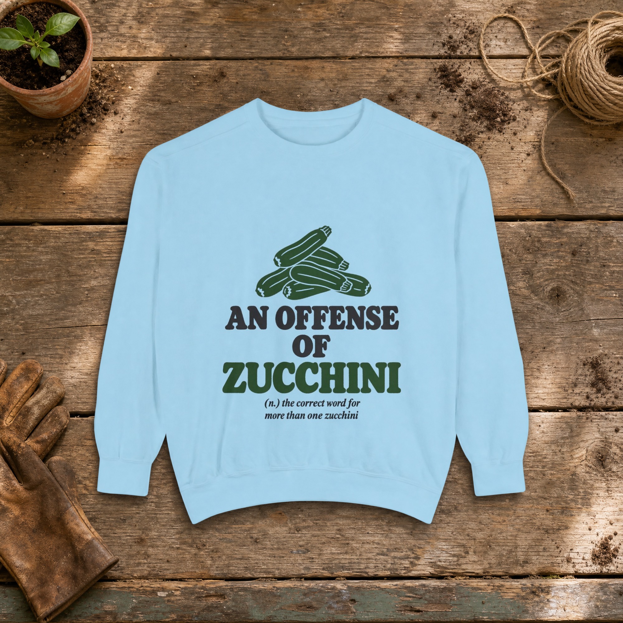 An Offense of Zucchini Sweatshirt in Chambray, a crewneck sweatshirt on a potting bench